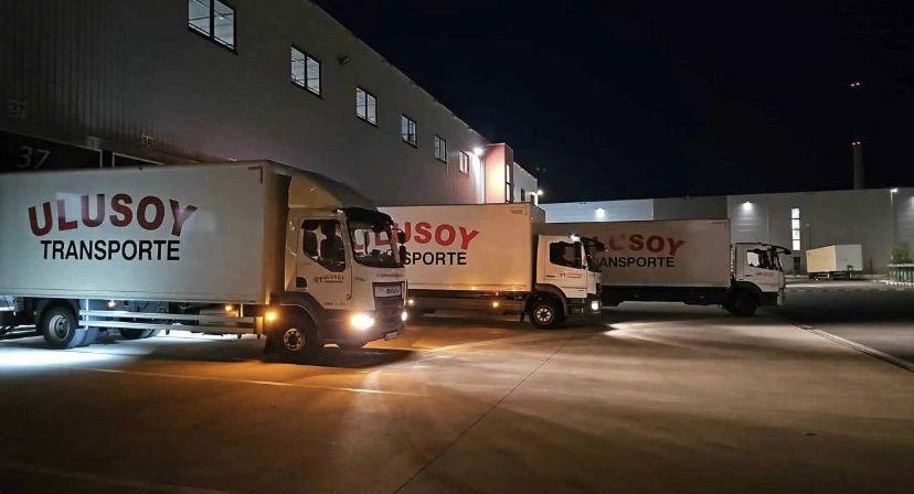 Drei Fahrzeuge von Ulusoy Transporte nachts vor der Logistikhalle