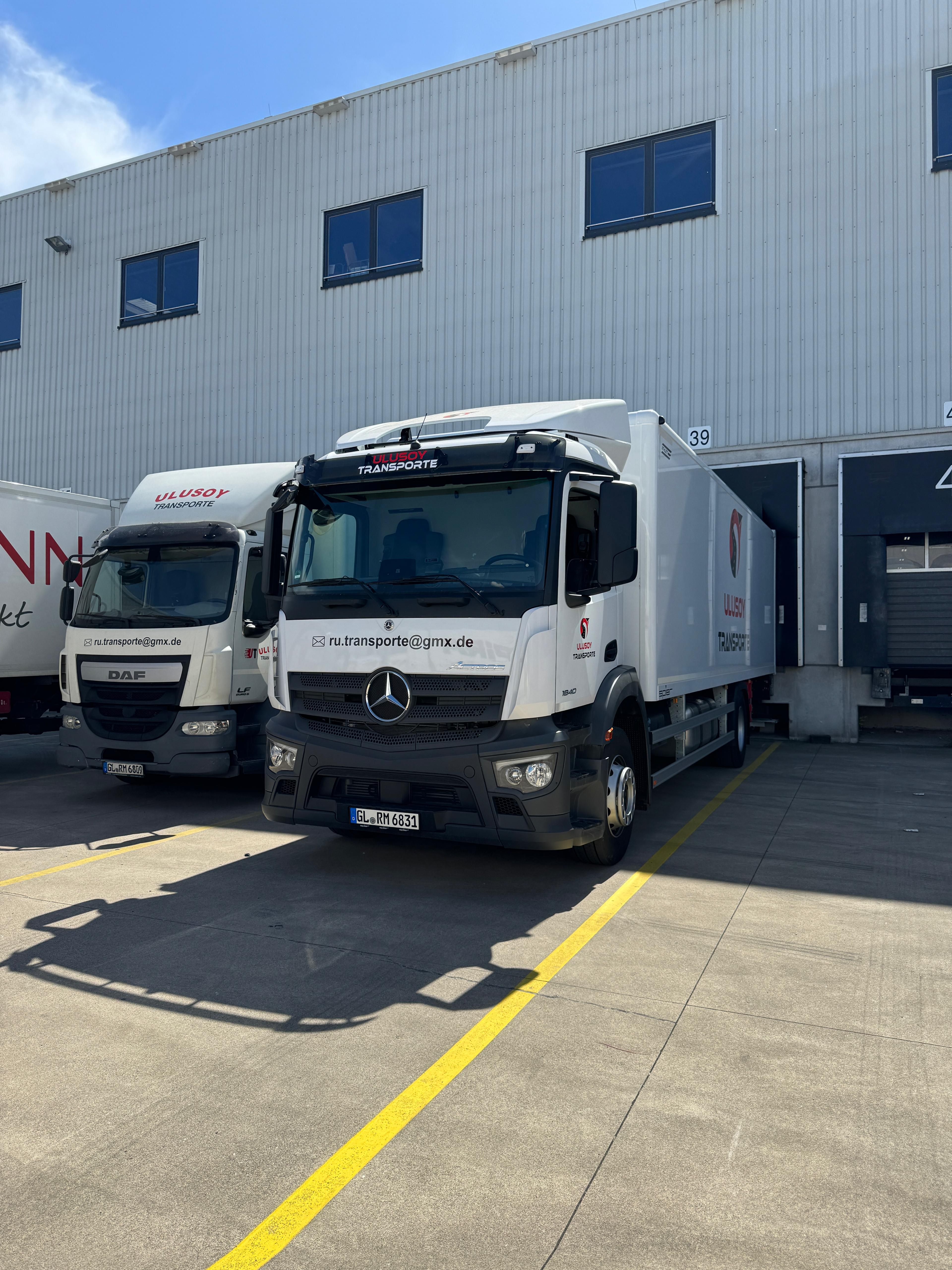 Verteilerfahrzeuge von Ulusoy Transporte vor der Logistikhalle